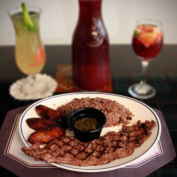 Cuban Cafe's grilled steak, rice and beans, plantains, and dipping sauce, with drinks.